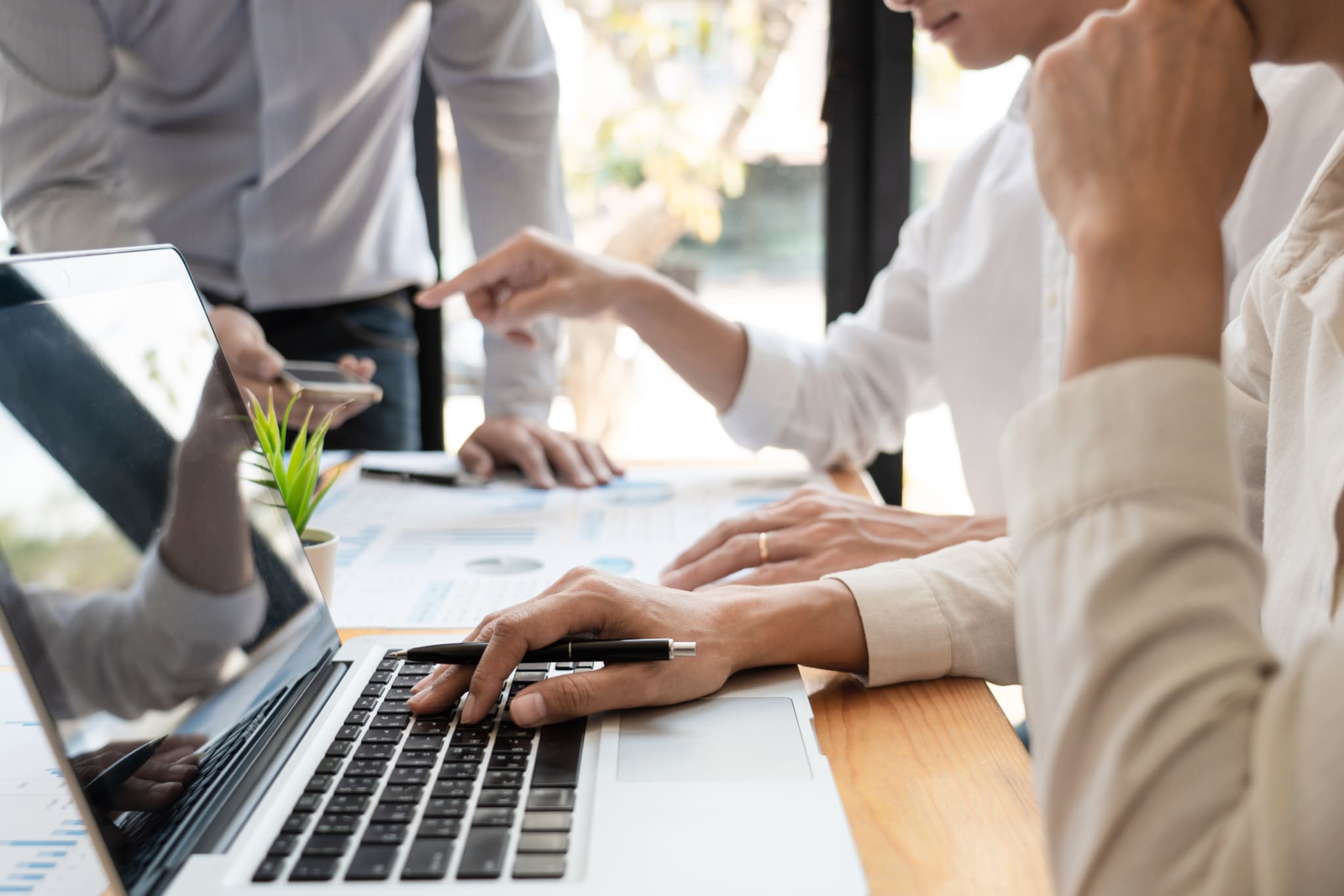 Multiple people working on a laptop together