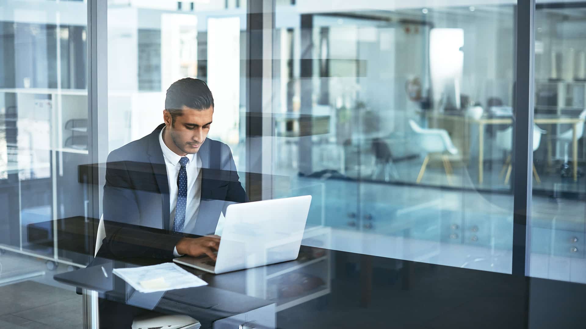 Man typing on a laptop in an office