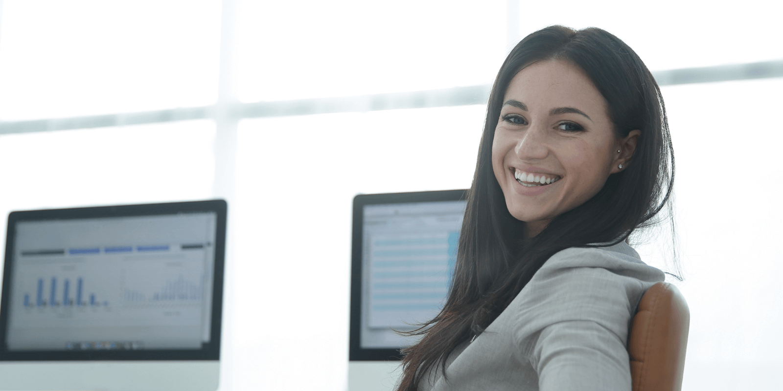 Woman smiling using a desktop at the office