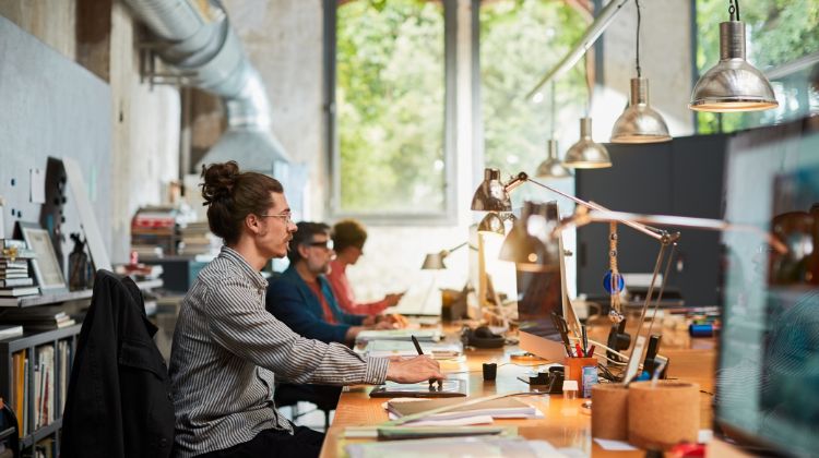 Multiple people working in the office using a digital drawing pad