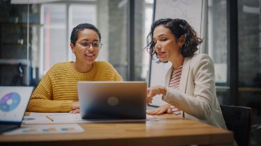 Two women using a laptop together