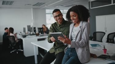 Two people using a tablet in the office