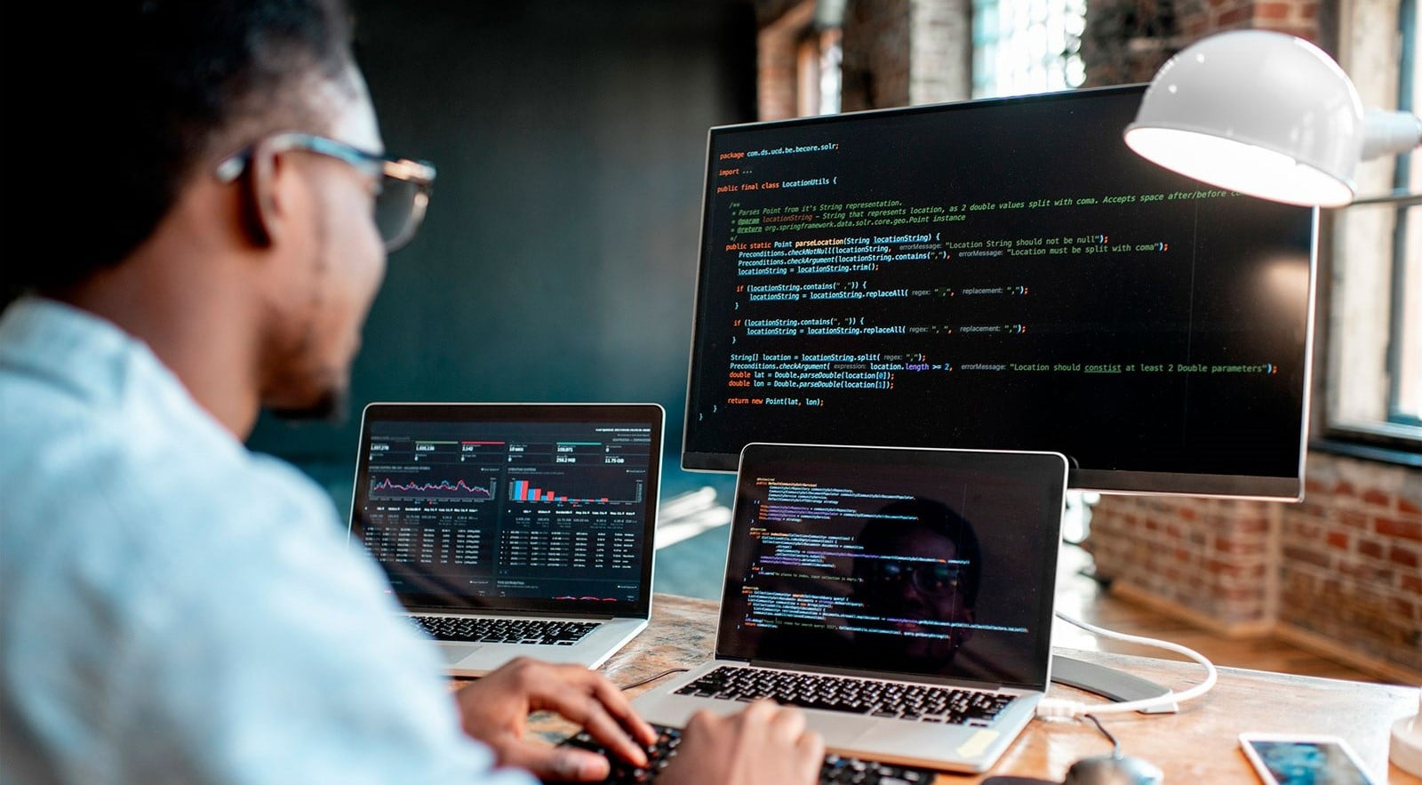 Man in front of three screens