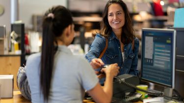 Woman smiling and buying something in a store