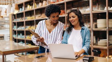 Two women working on a laptop together