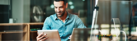 Man working on a tablet and laptop