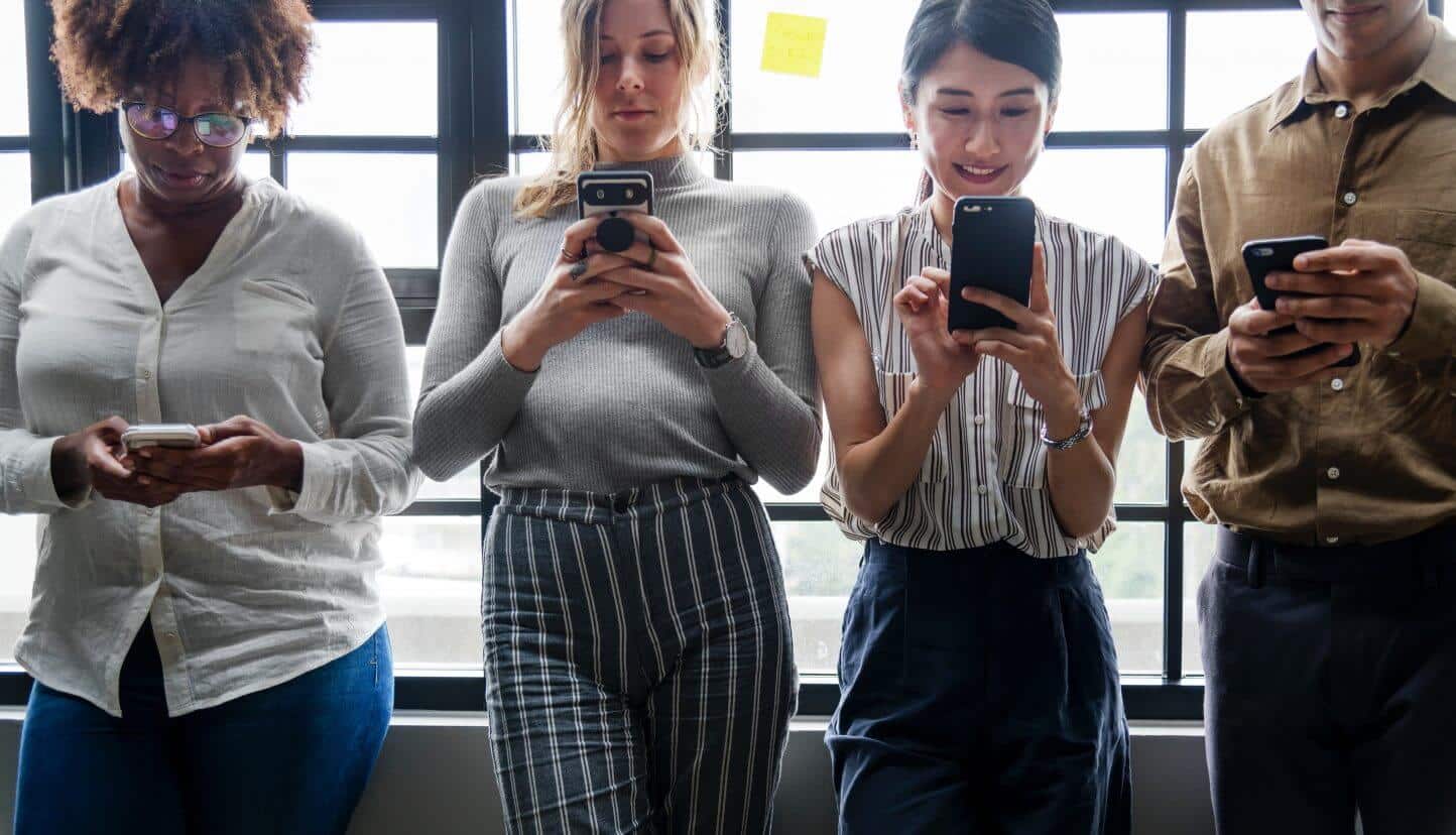 Four people looking at their cell phones