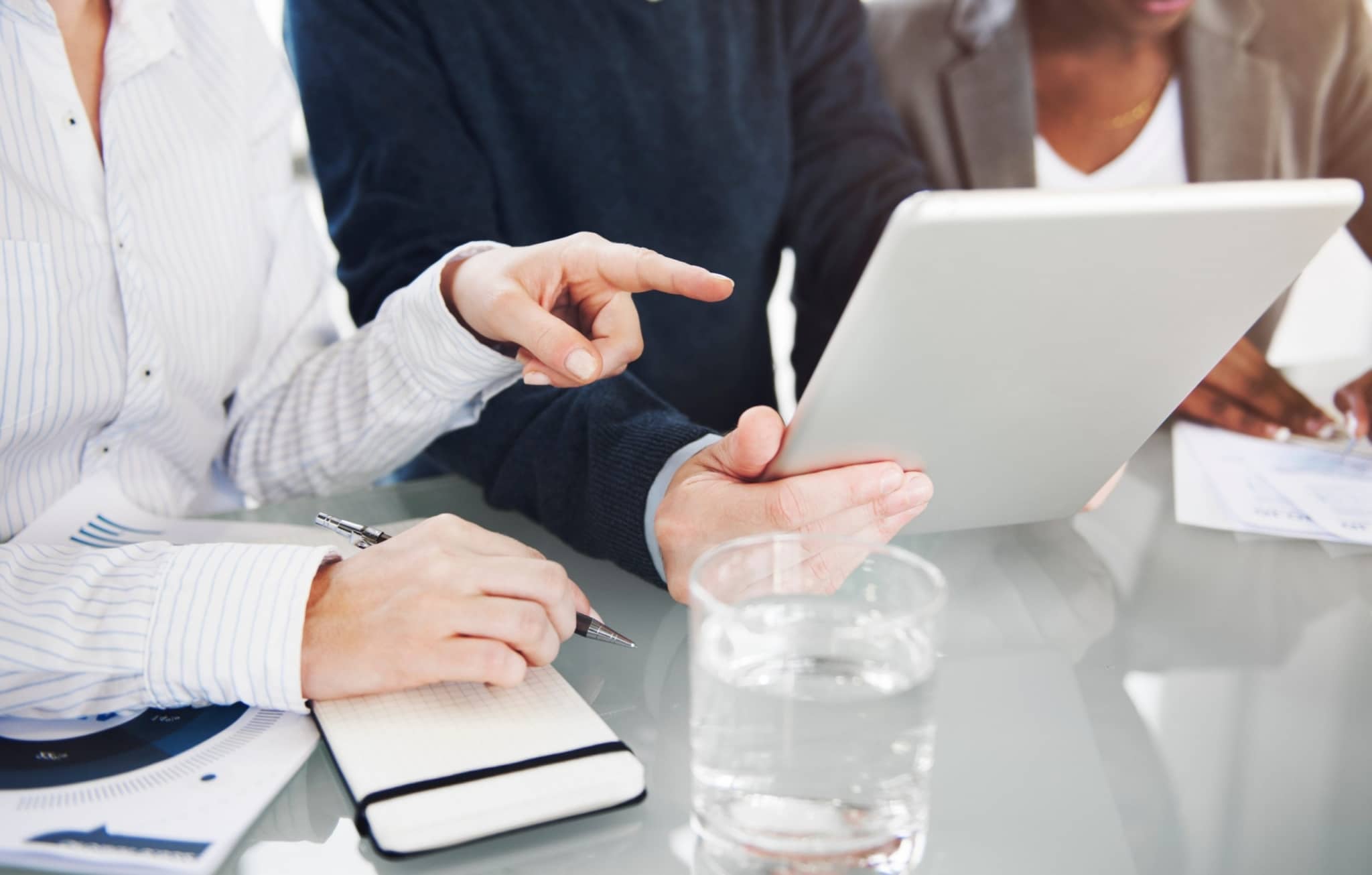 Three business people, looking at a tablet