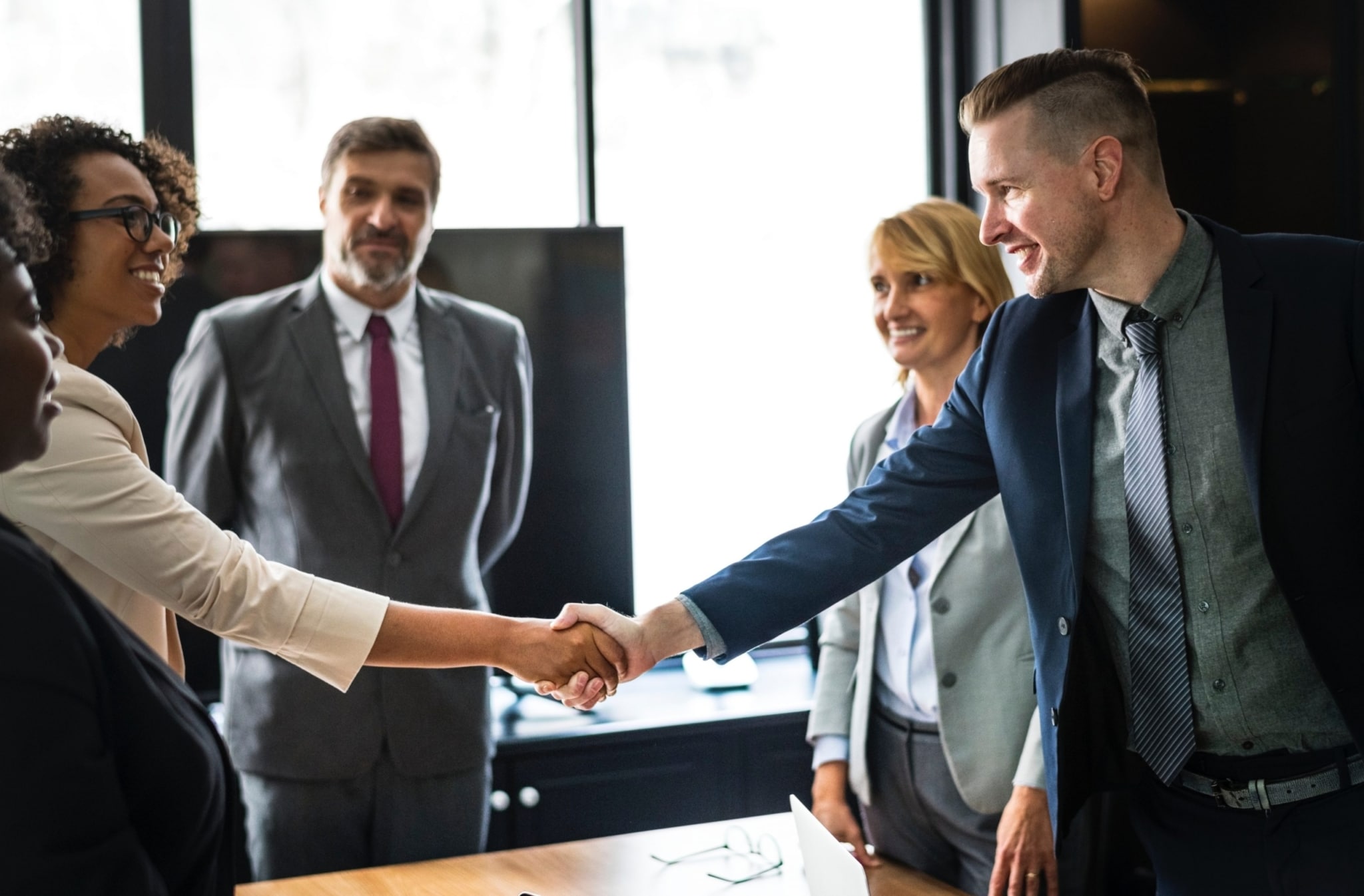 Four business people, shaking hands with each other