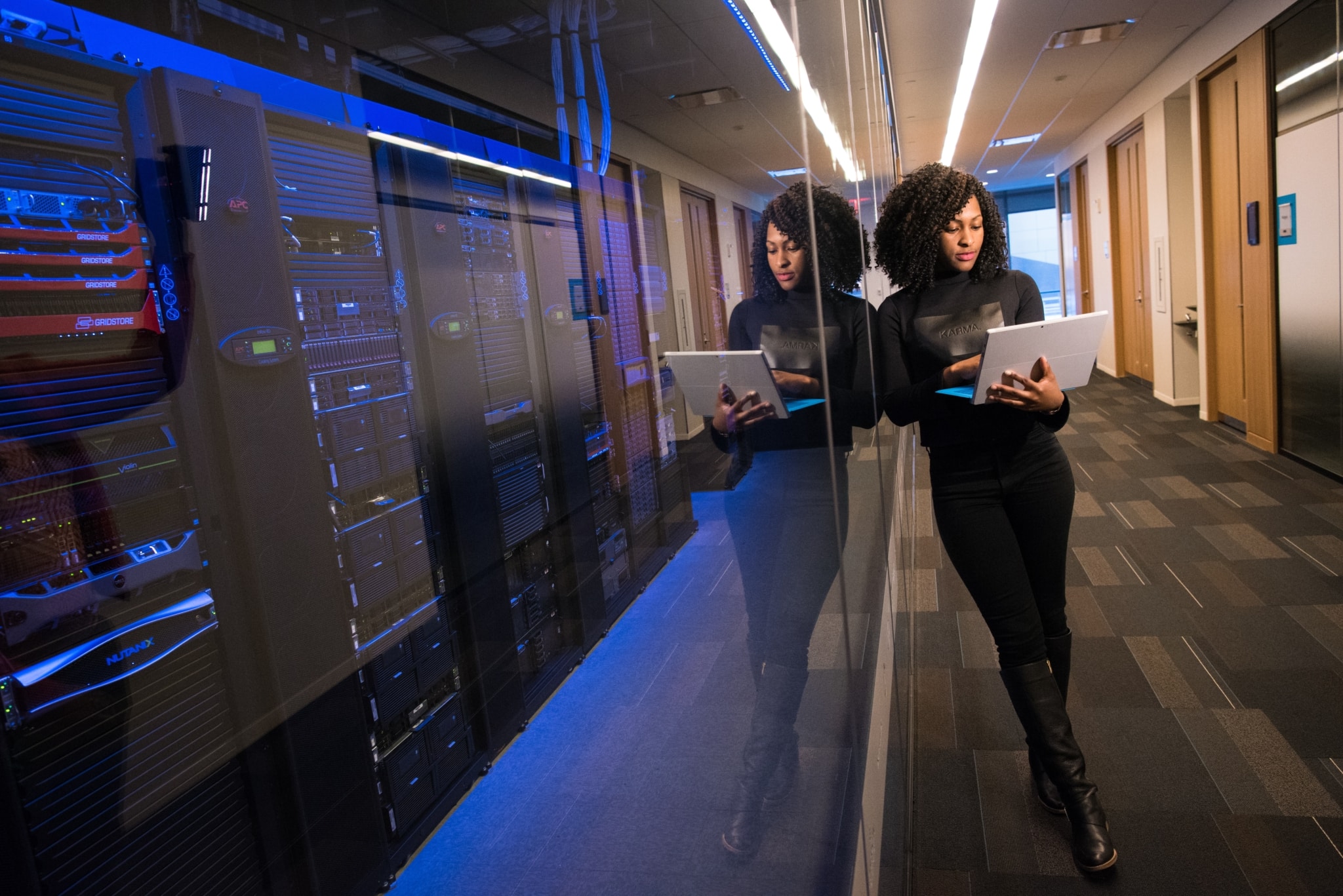 Woman working on a laptop in a server room